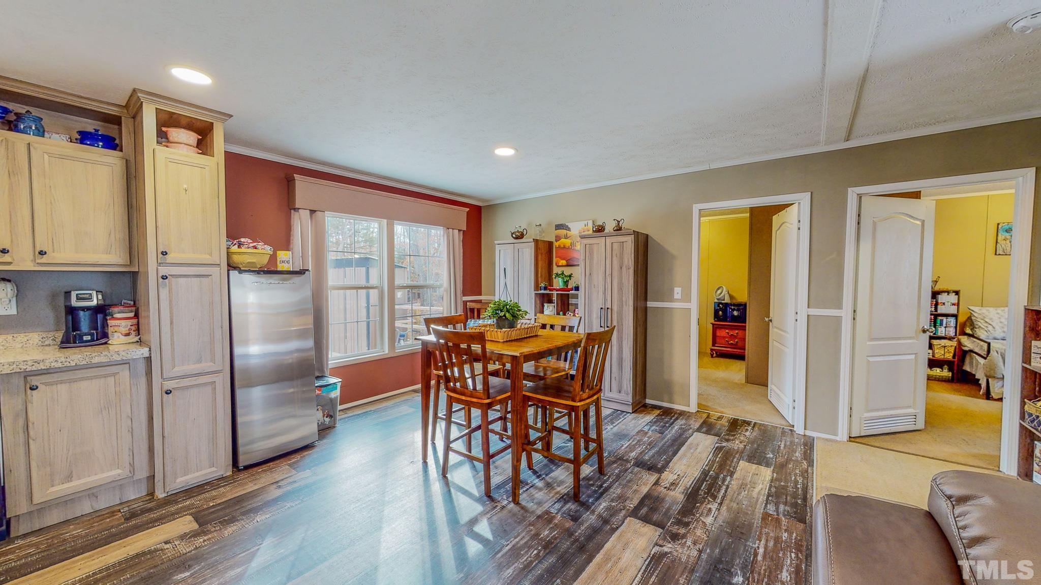 100 Marco Road Roxboro, NC 27574 - Photo 10 of 47 a kitchen with stainless steel appliances granite countertop a refrigerator a stove a dining table and chairs with wooden floor