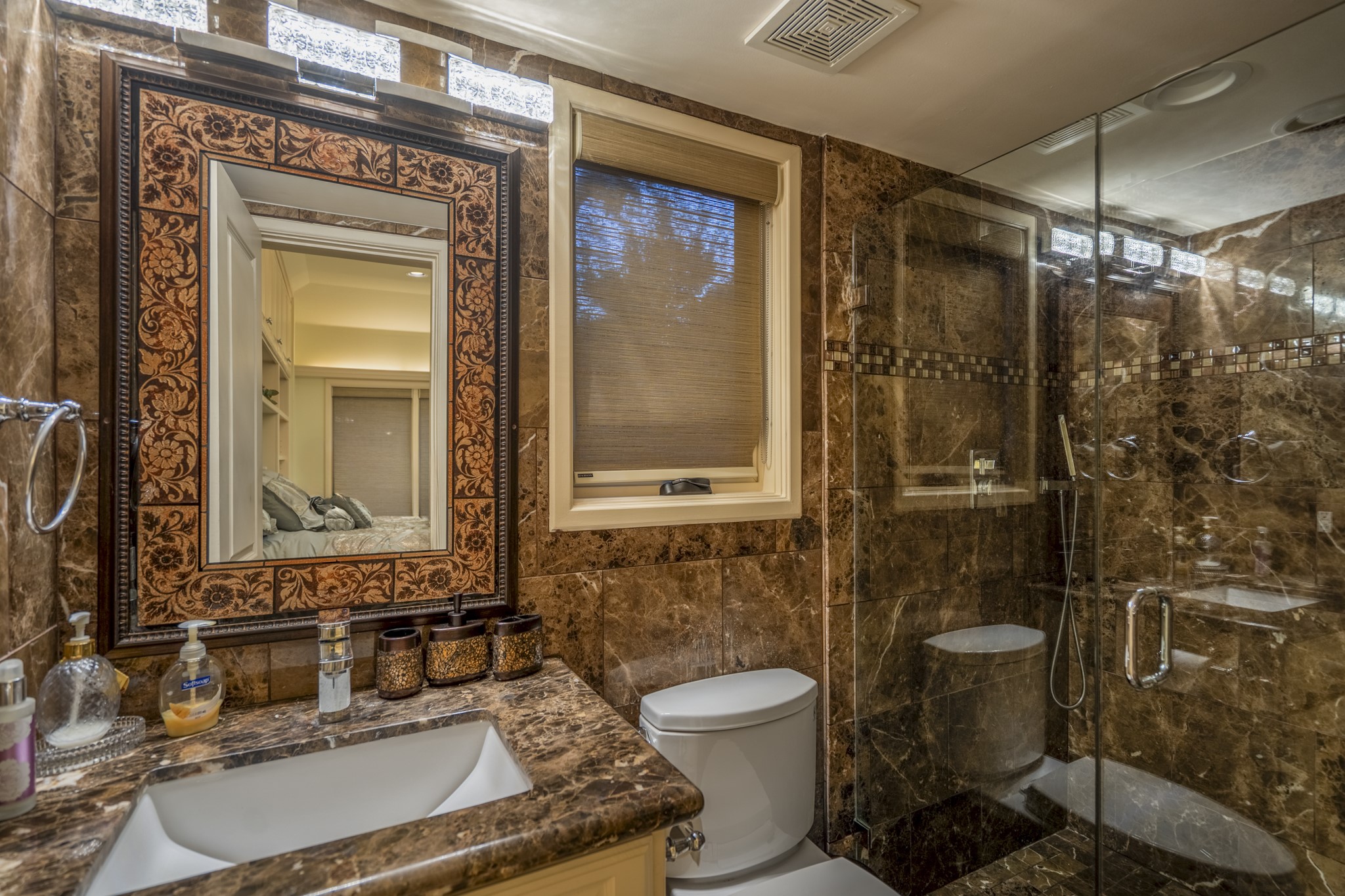 6535 Buffalo Speedway Houston, TX 77005 - Photo 36 of 40 The guest house bathroom mirrors the quality of the main home with bold tilework, upgraded fixtures, and walk-in shower.