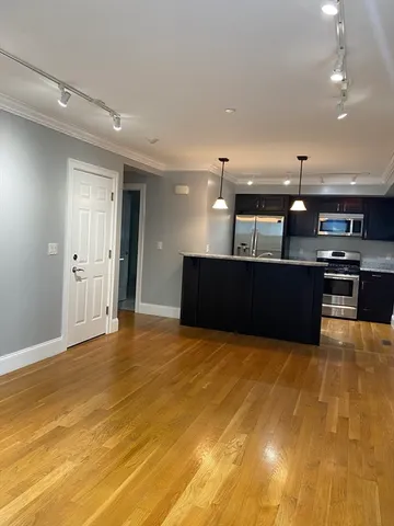a view of kitchen with kitchen island and stainless steel appliances