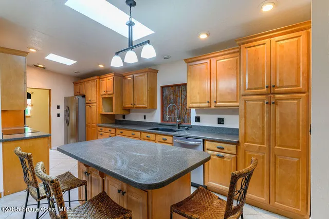 a kitchen with a table chairs refrigerator and cabinets