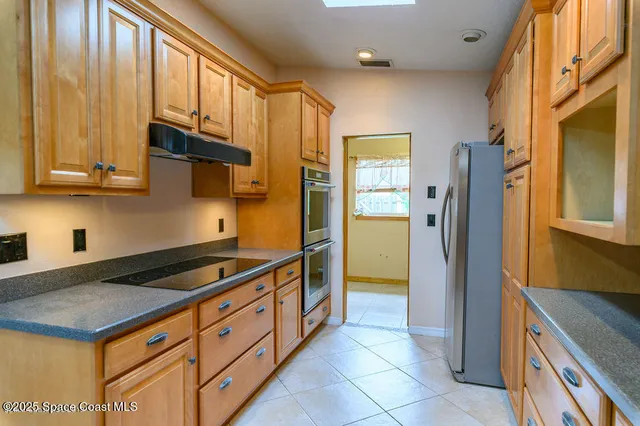a kitchen with a table chairs refrigerator and cabinets