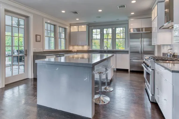 a kitchen with stainless steel appliances granite countertop a sink a stove and a wooden floors
