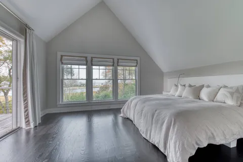 a bed sitting in a bedroom next to a large window
