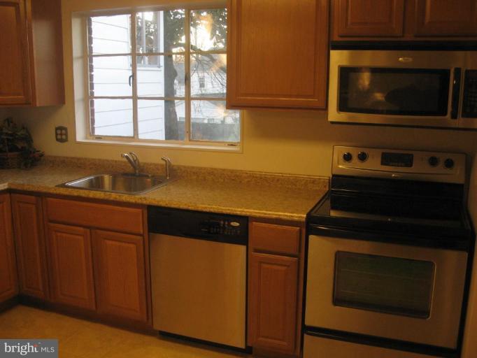 2007 Cascade Road Silver Spring, MD 20902 - Photo 8 of 12 a kitchen with granite countertop cabinets stainless steel appliances and a window