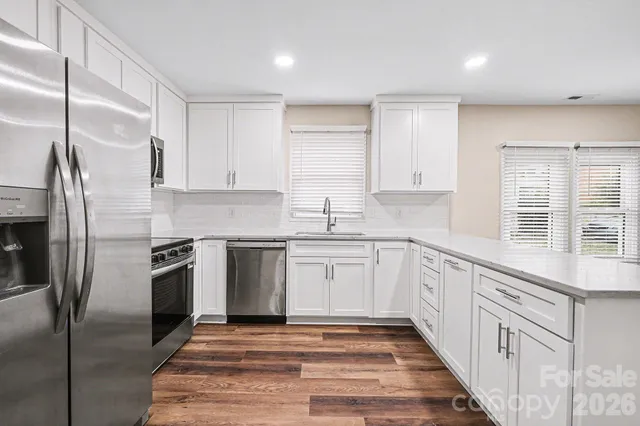 a kitchen with granite countertop a refrigerator and a sink