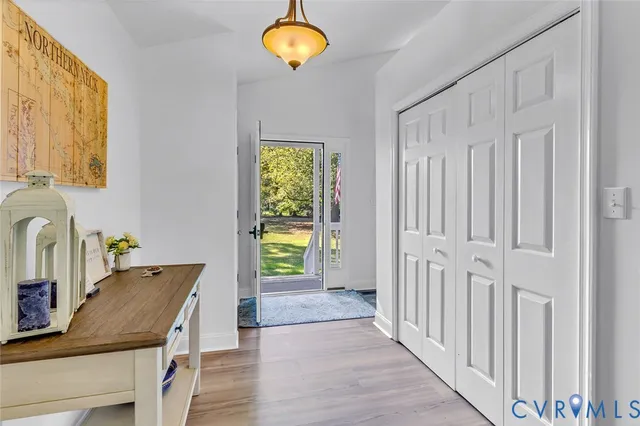 a room with kitchen island a chandelier and wooden floor