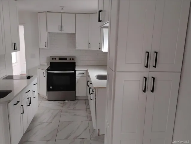 a kitchen with granite countertop white cabinets and white appliances