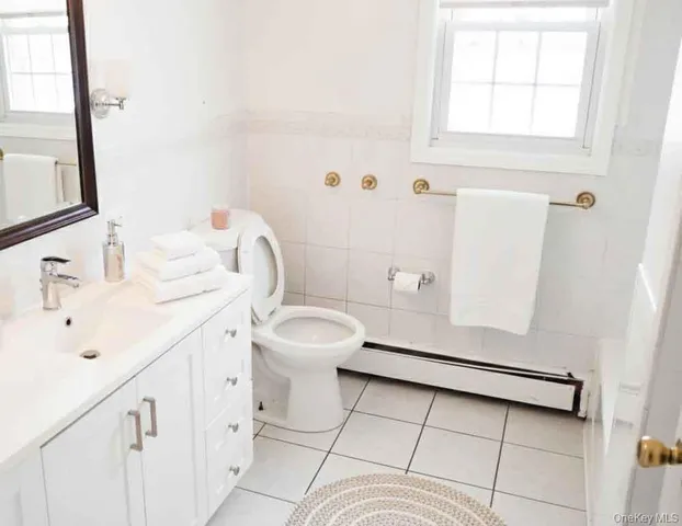 a bathroom with a sink a toilet and a window