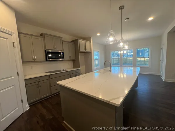a kitchen with kitchen island a sink appliances and cabinets