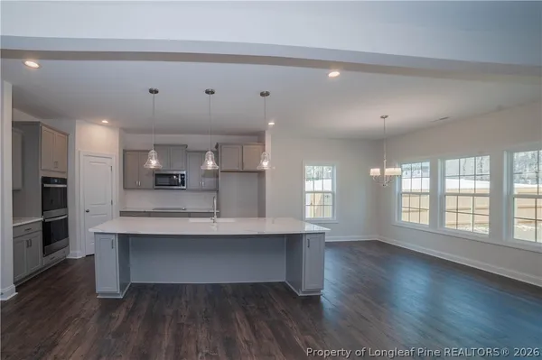 a view of an empty room with wooden floor and a fireplace
