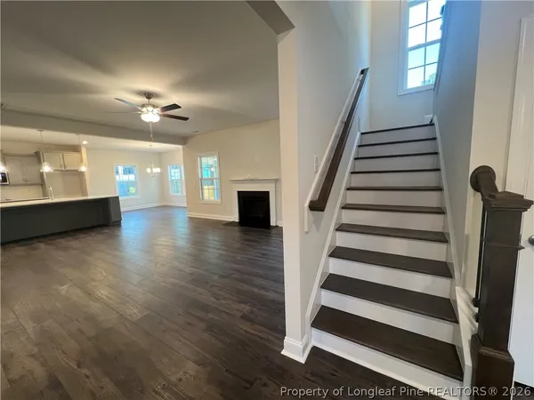 a view of a hallway with wooden floor and windows