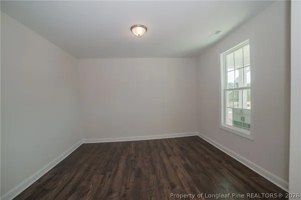an empty room with a window and a ceiling fan