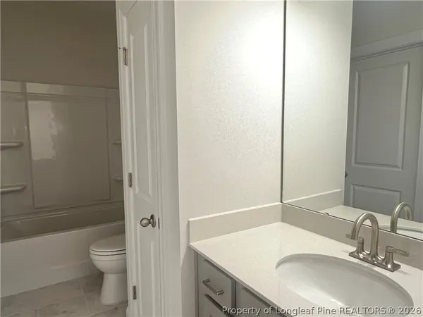 a bathroom with a granite countertop sink toilet a mirror and shower