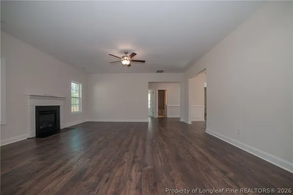 a view of a room with wooden floor and a ceiling fan