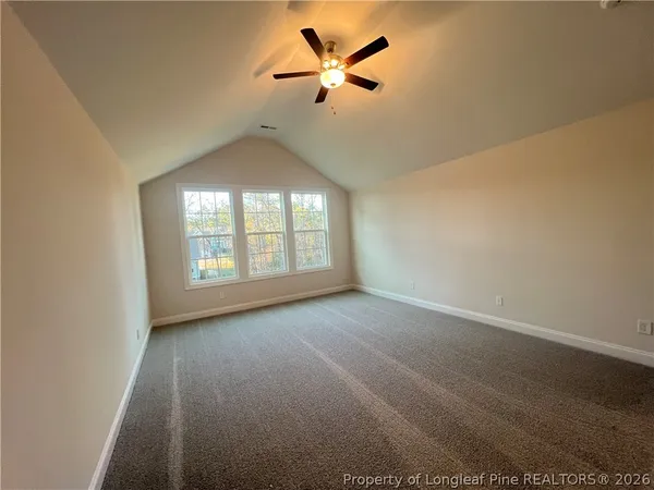 an empty room with a window and a ceiling fan
