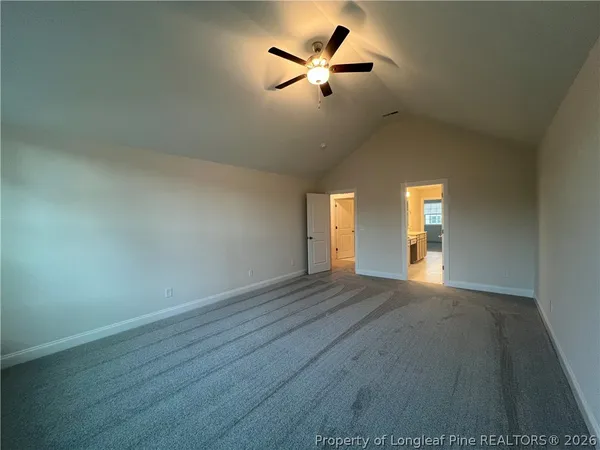 an empty room with wooden floor chandelier fan and windows