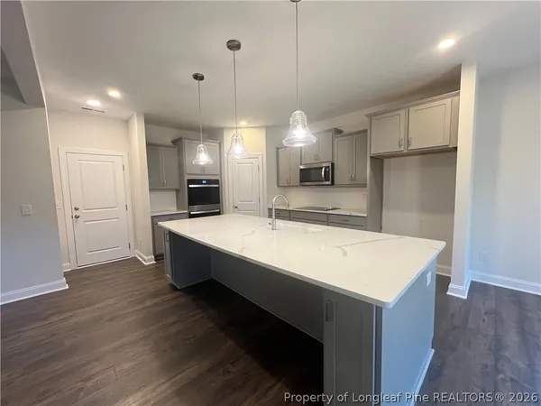 a large white kitchen with a refrigerator a sink and a stove