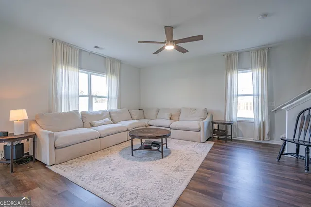 a living room with furniture and a wooden floor