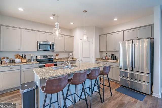 a kitchen with kitchen island granite countertop a refrigerator stove microwave and cabinets