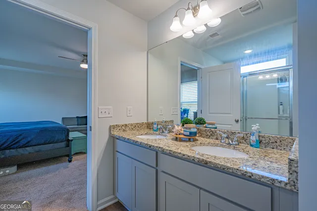 a en suite bathroom with a double vanity sink and a mirror