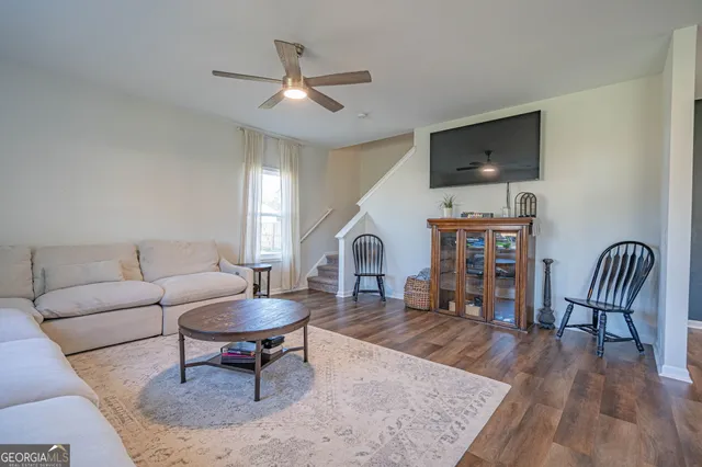 a living room with furniture a rug and a flat screen tv