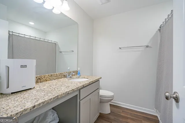 a bathroom with a granite countertop sink toilet and shower