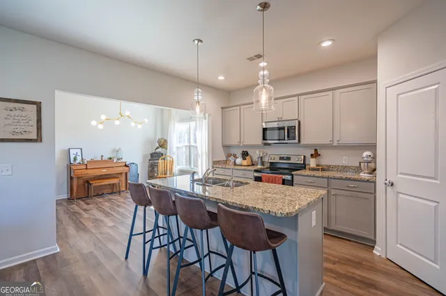 a kitchen with a dining table chairs refrigerator and microwave
