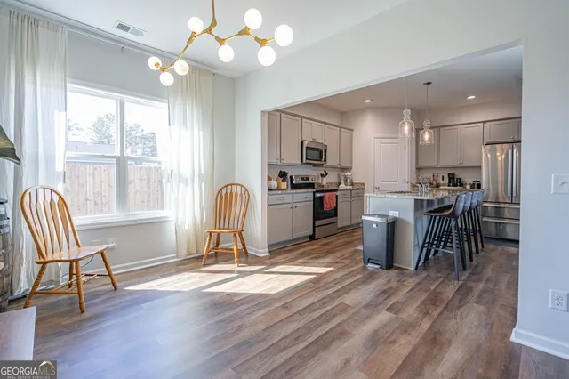 a view of a dining room with furniture a chandelier and wooden floor
