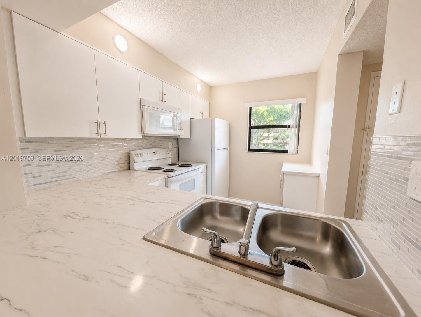 3410 Foxcroft Road, Unit 206 Miramar, FL 33025 - Photo 4 of 23 a kitchen with a sink cabinets and window