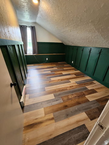320 South State Street Preston, ID 83263 - Photo 10 of 20 Bedroom with light wood-type flooring, lofted ceiling, a wainscoted wall, and a decorative wall