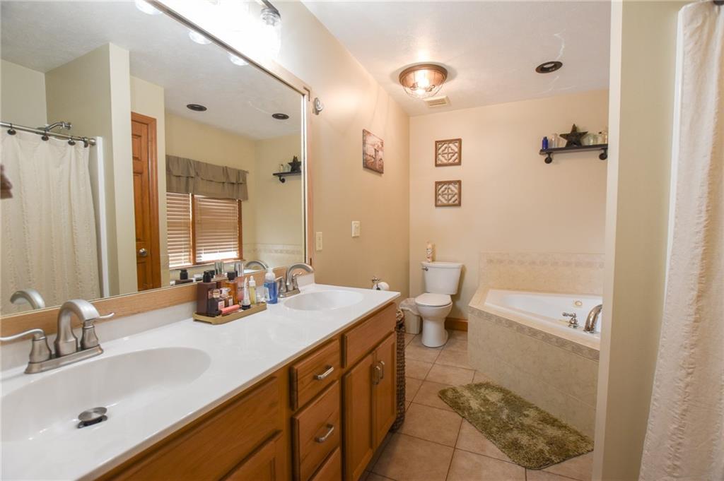252 Becker Road Butler, PA 16002 - Photo 12 of 23 a bathroom with a double vanity sink toilet and shower