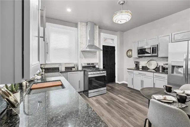 a large kitchen with kitchen island granite countertop a stove a sink and a refrigerator