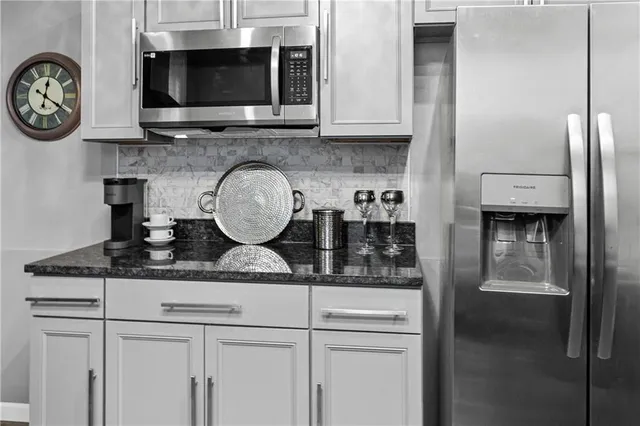 a kitchen with stainless steel appliances granite countertop a stove and a microwave
