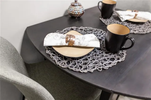 a table with chairs and a vase of books on it