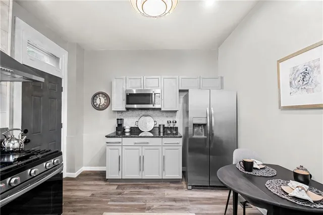a kitchen with stainless steel appliances kitchen island granite countertop a sink stove and refrigerator