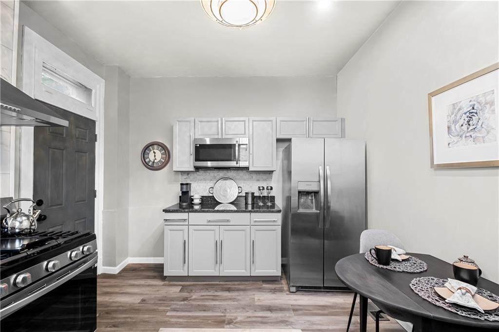 1256 Superior Avenue Pittsburgh, PA 15212 - Photo 30 of 50 a kitchen with stainless steel appliances kitchen island granite countertop a sink stove and refrigerator