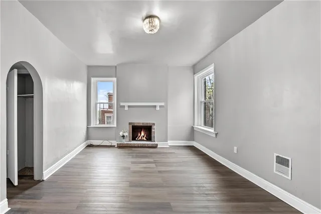 a view of empty room with wooden floor and windows