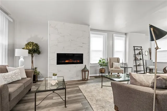 a living room with furniture a large window and a flat screen tv