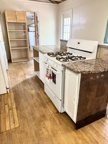 a white stove top oven sitting inside of a kitchen