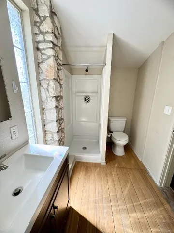 a bathroom with a sink a toilet and shower