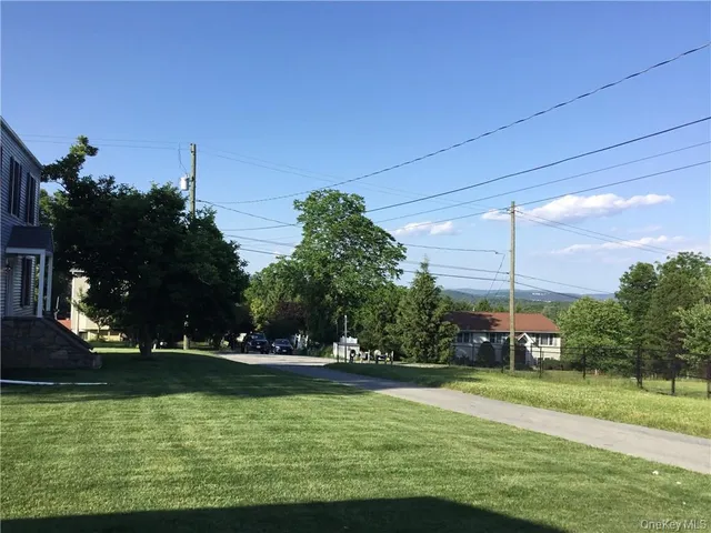 a view of a fountain in front of a house with a big yard