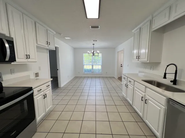 a kitchen with a sink a stove and cabinets