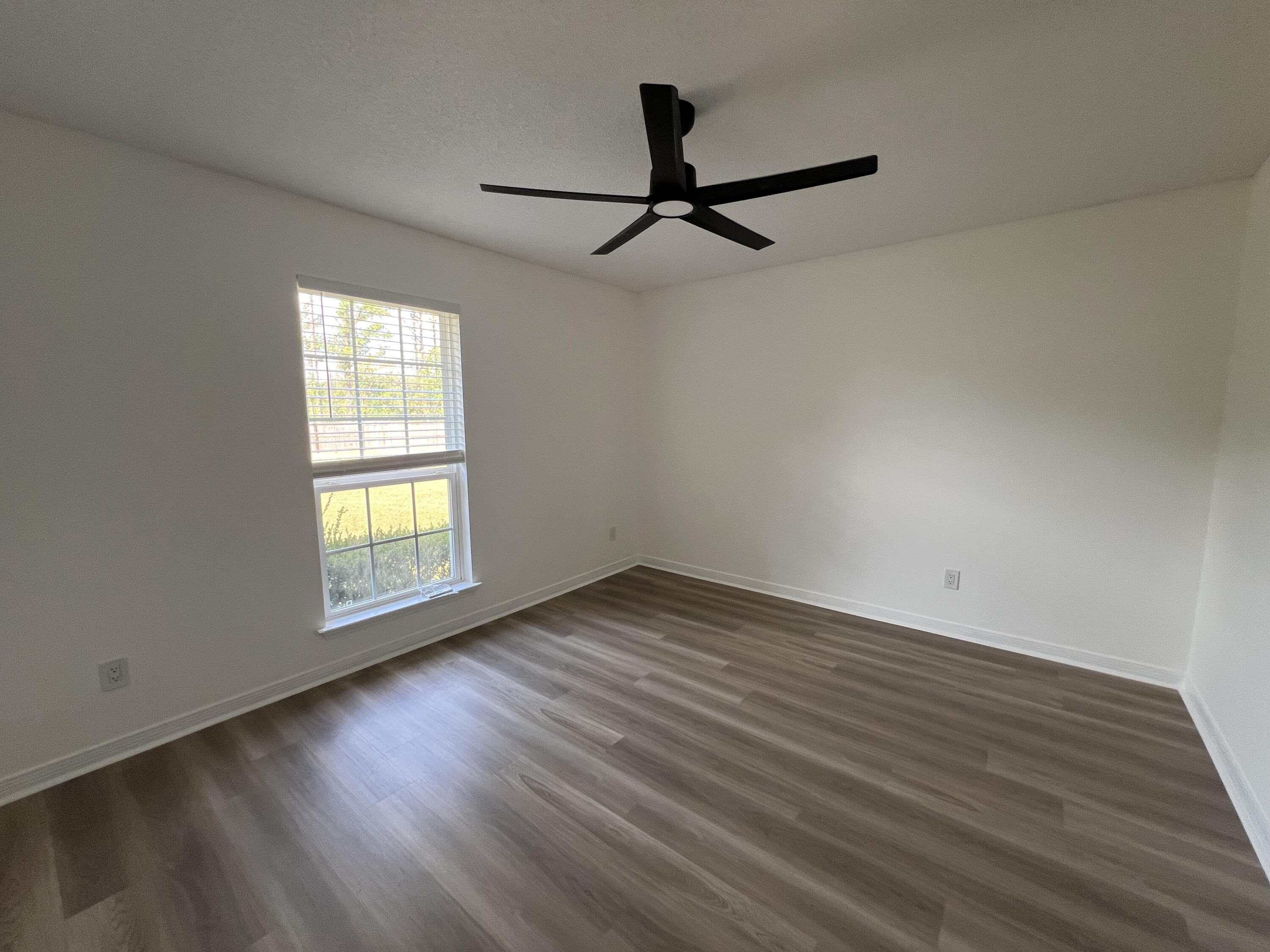 5330 John Lowery Road Jay, FL 32565 - Photo 6 of 30 an empty room with wooden floor fan and windows