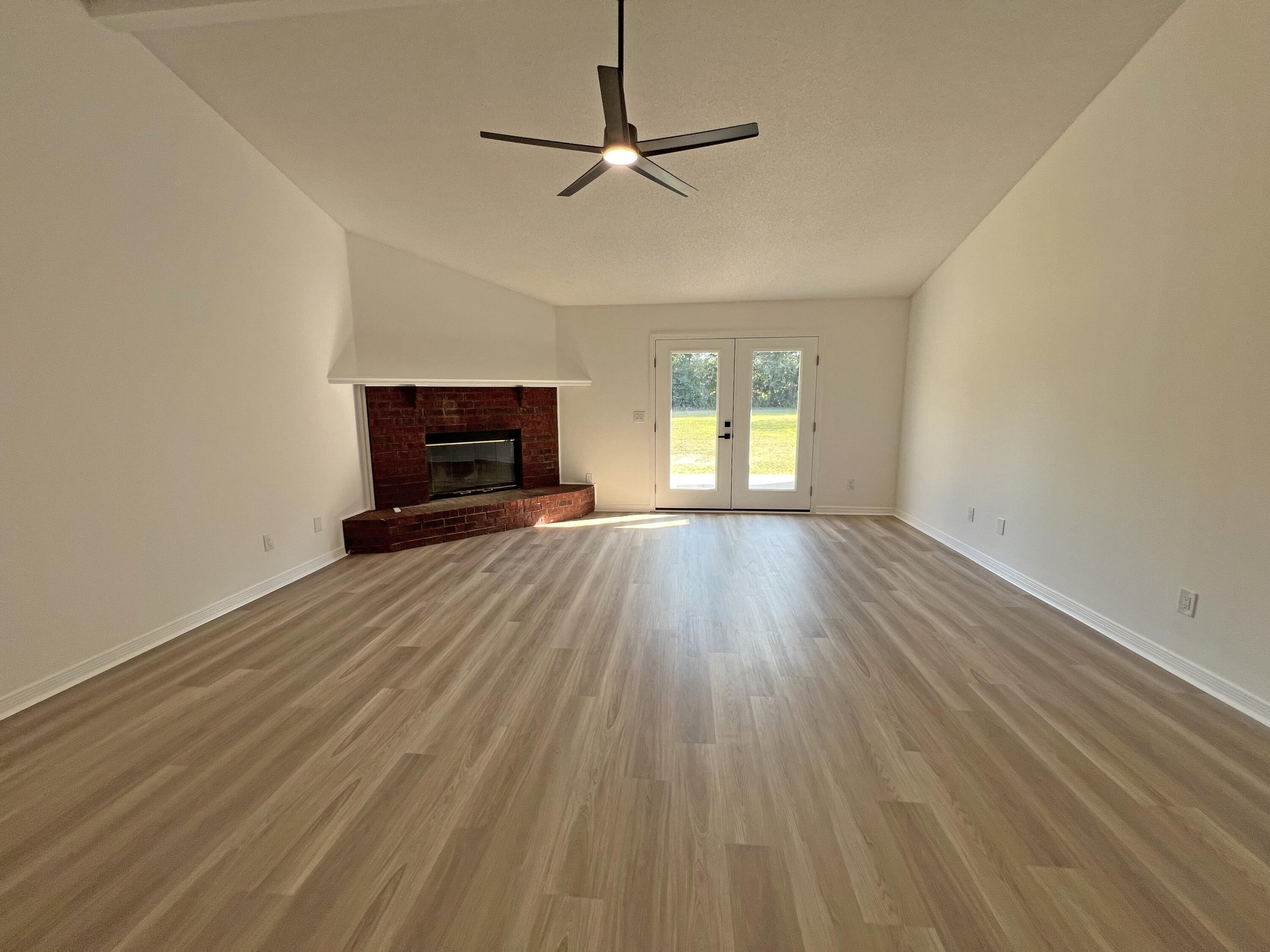 5330 John Lowery Road Jay, FL 32565 - Photo 8 of 30 an empty room with wooden floor ceiling fan and windows