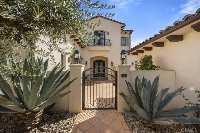 a view of a house with a small yard and large tree