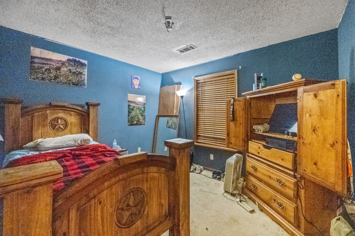 71 Shady Oaks Point Blank, TX 77364 - Photo 17 of 32 a bedroom with a bed and wooden floor