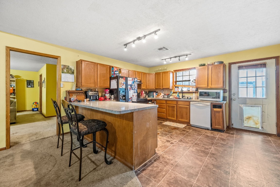 71 Shady Oaks Point Blank, TX 77364 - Photo 7 of 32 a kitchen with a table chairs refrigerator and window