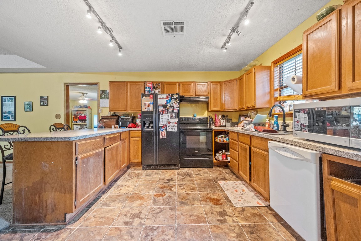 71 Shady Oaks Point Blank, TX 77364 - Photo 9 of 32 a large kitchen with stainless steel appliances kitchen island granite countertop a sink counter space cabinets and a large window