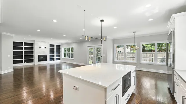 a view of empty room with wooden floor and a window