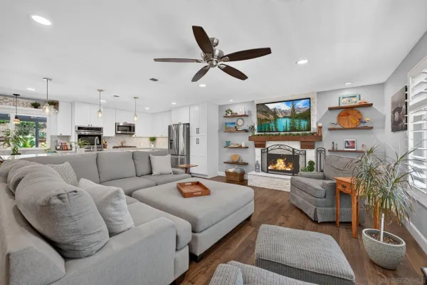 a living room with furniture kitchen view and a window